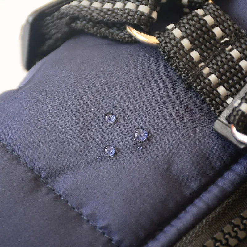 Close photo of water staying on top of the waterproof dog jacket with harness in blue.