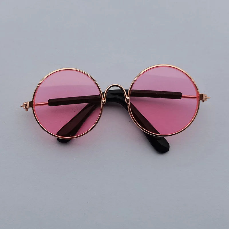 Pink dog sunglasses with gold frame.